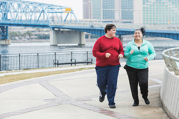 Overweight people exercising, running and smiling