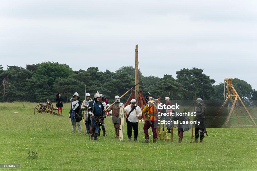 Medieval Warfare at the Old Hall Cheshire Chester, UK - June 19, 2016: The Medieval Fayre, in association with Plantagenet Events. Hundreds of re-enactors make this one of the most atmospheric events in the living history calendar.  A smallgroups of rebels wait by the work machines Acting - Performance Stock Photo