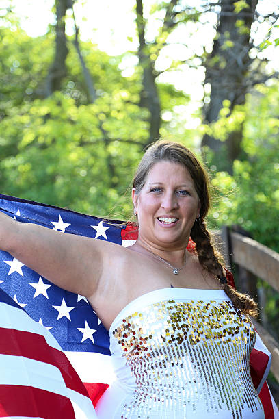 istock Female Poses With U. S. Flag Stretched Behind Her 541837672
