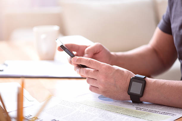 istock Man holding a phone on the table 541837828