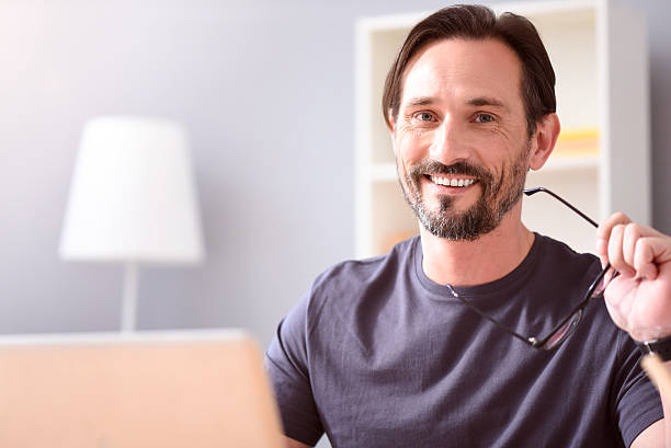 istock Man holding glasses and looking at camera 541837896
