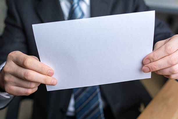 istock businessman holding white blank paper 541842034