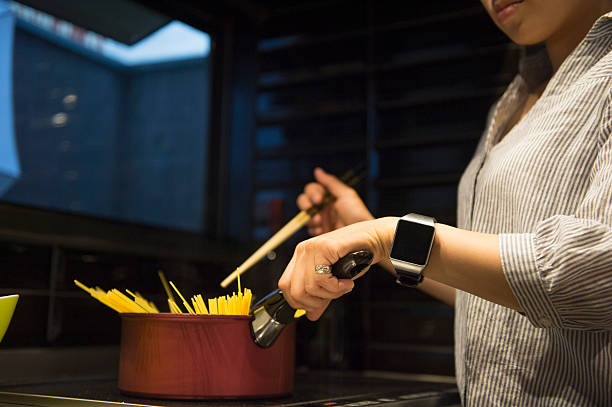 Woman boiling pasta at home