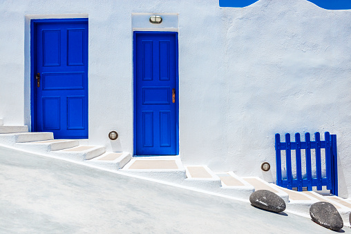 Bright morning scene of Oia (Ia) village on Santorini, Greece. Oia with Traditional White Houses with Blue Doors in Santorini, Greece.