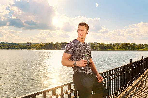 athlete resting   in park with bottle of water. - hip flask audio imagens e fotografias de stock