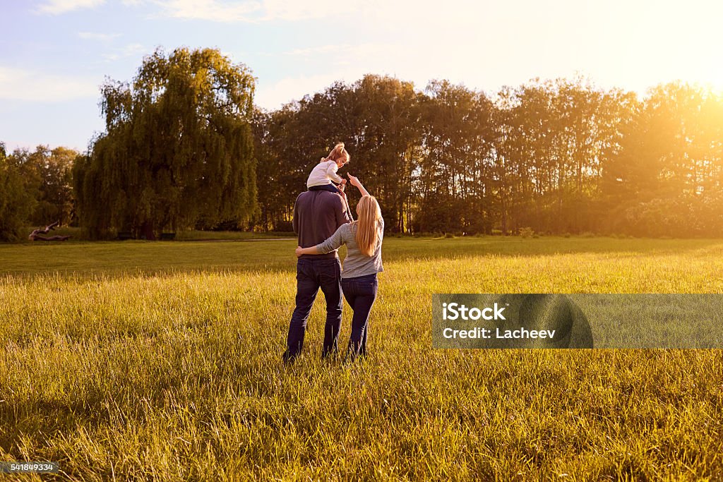 Happy family concept. Happy family concept. Mom, dad and daughter walking in the park in the evening. Family Stock Photo