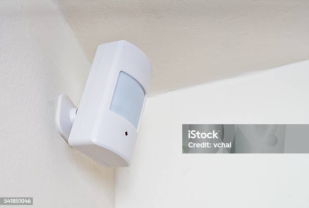 Motion Sensor Or Detector For Security System Mounted On Wall Stock Photo - Download Image Now