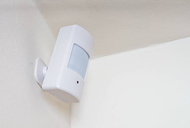 motion sensor or detector for security system mounted on wall. - security system security burglar alarm residential structure imagens e fotografias de stock