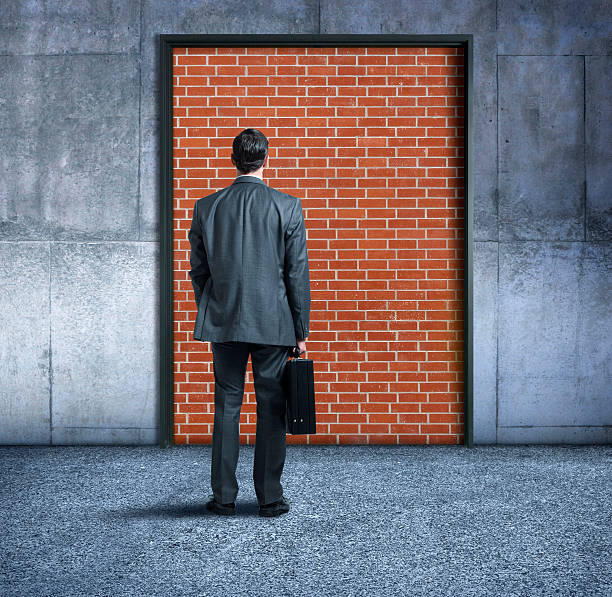 istock Businessman Standing In Front Of Exit Blocked By Brick Wall 541851050