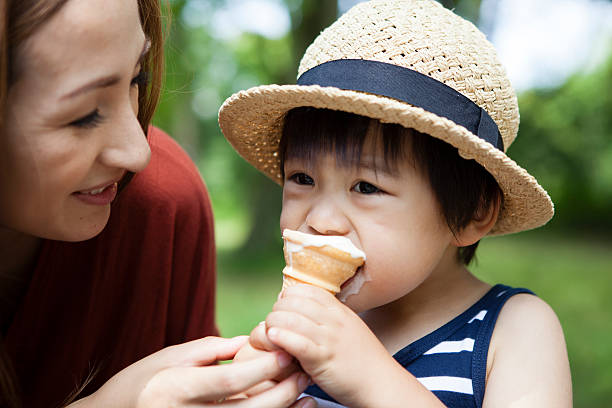 istock Boy eating a mom and ice in the park 541851276