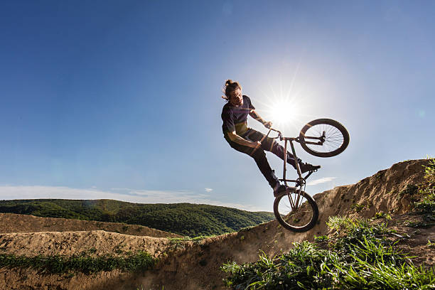 istock Extreme cyclist practicing on dirt road against the sky. 541851972