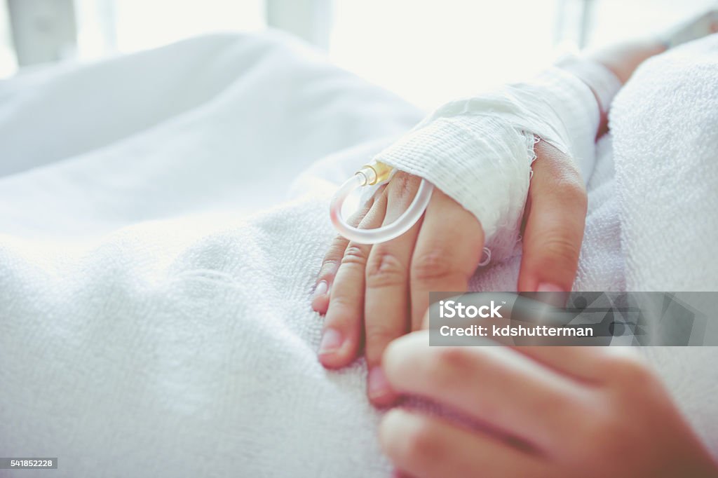 Saline intravenous (iv) drip in a child's patient hand. Vintage Close up of saline intravenous (iv) drip in a child's patient hand. Health care and people concept. Vintage tone. Child Stock Photo