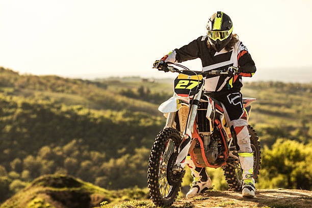 Dirt bike racer on his enduro motorcycle  on extreme terrain. Motocross rider on his stunt bike spending a day in nature. bmx racing stock pictures, royalty-free photos & images