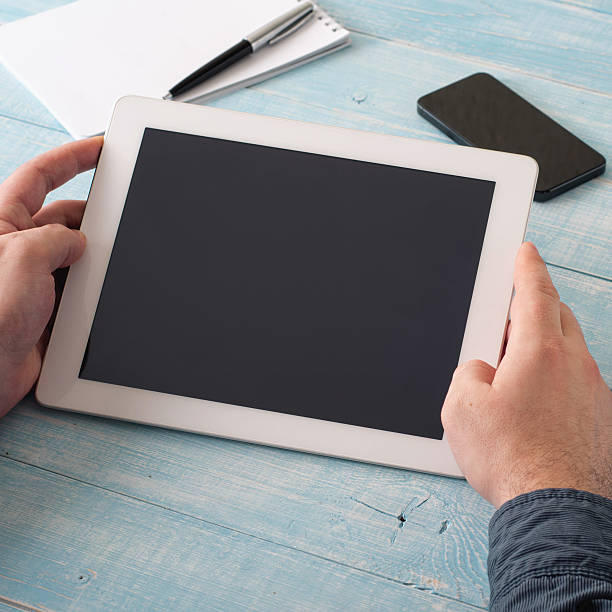 istock Man holding tablet in hand with blank screen 541853876