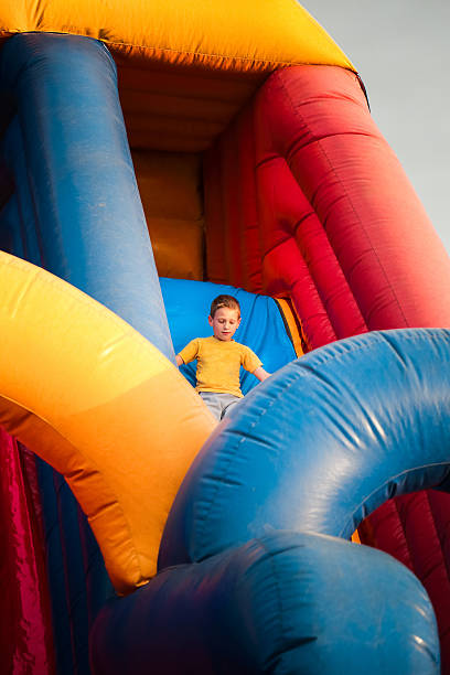 istock 7 years boy play on inflatable bouncy castle slide 541857110