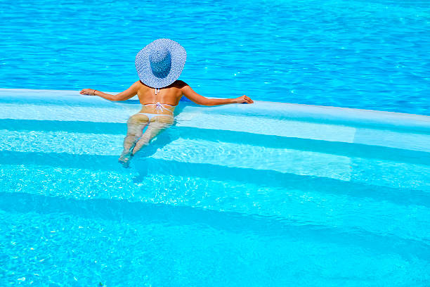 istock woman relaxing at a resort swimming pool 541857588