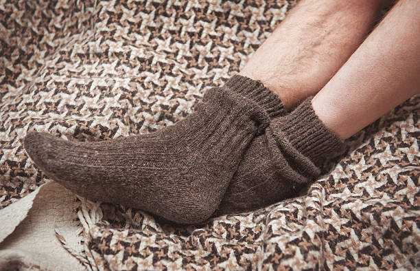 istock Man feet on woolen plaid in socks 541864042