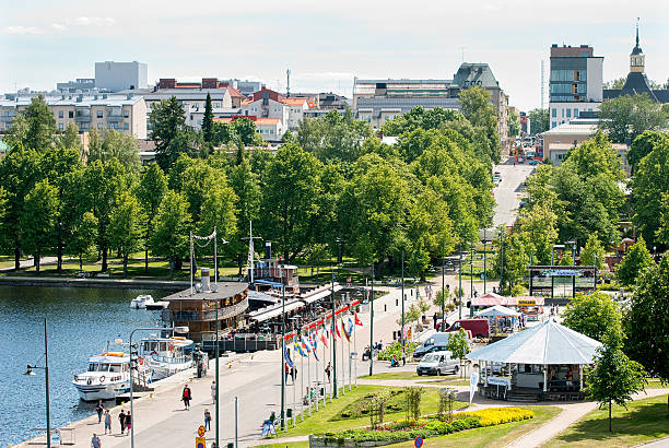 Lappeenranta. Finland. People on the embankment Lappeenranta, Finland - June 15, 2016: People walk on the embankment near Harbor Square (Satamatori), restaurants on Saima Lake. On the background is the part of the town with Saint Mary Church  lappeenranta stock pictures, royalty-free photos & images