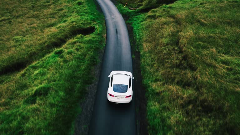 Aerial view electric car driving on country road