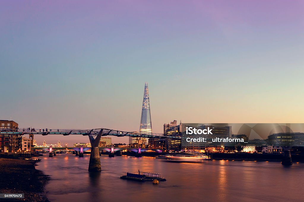 Millennium Bridge and The Shard in London at twilight View of Millennium Bridge, The Shard, Southwark Bridge and Tower Bridge in a pink twilight London - England Stock Photo