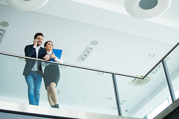 istock Low angle view of two business people multi-tasking. 541970776