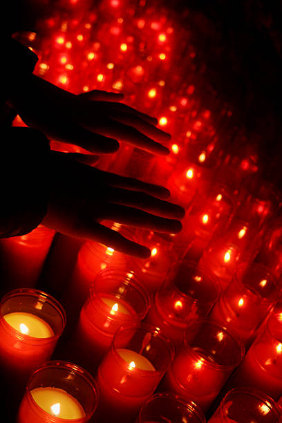 istock Group of candles with two hands silhouetted. 541975374