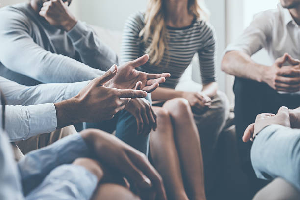 Close-up on discussion. Close-up of people communicating while sitting in circle and gesturing form of communication stock pictures, royalty-free photos & images