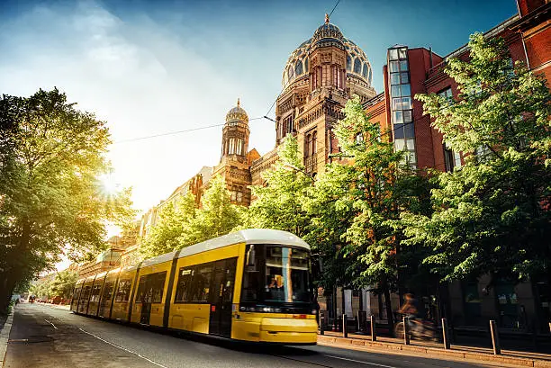 yellow train passing synogoge in Berlin Friedrichstrasse at summer sunset