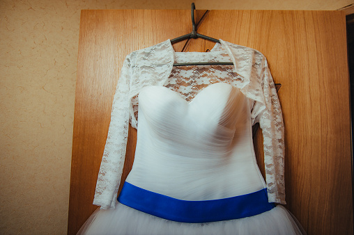 White Wedding dress on a shoulders before ceremony