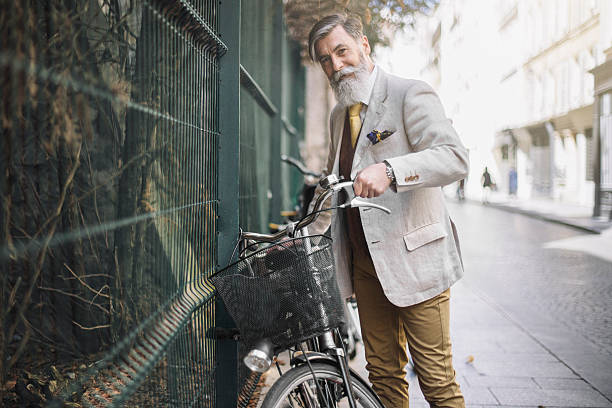 Portrait senior man picking his bicycle in the street Portrait of french senior man picking his bicycle in the street at Paris. hipster bike stock pictures, royalty-free photos & images