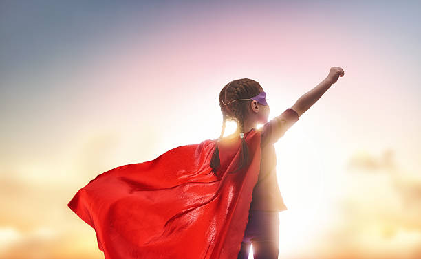 child plays superhero Little child plays superhero. Kid on the background of sunset sky. Girl power concept girl power photos stock pictures, royalty-free photos & images