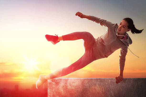 sporty woman outdoors young sporty woman outdoors. the girl is engaged in parkour. free running stock pictures, royalty-free photos & images