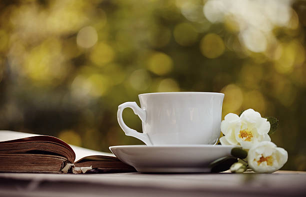 istock Old open book and a white cup with a wild roses 541987040