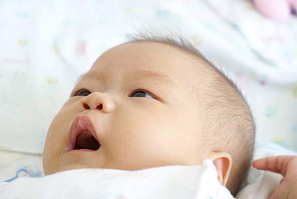 istock Cute infant lying and smiling on white bed. 541989884