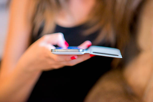 istock female reading text message on cell telephone 541990464