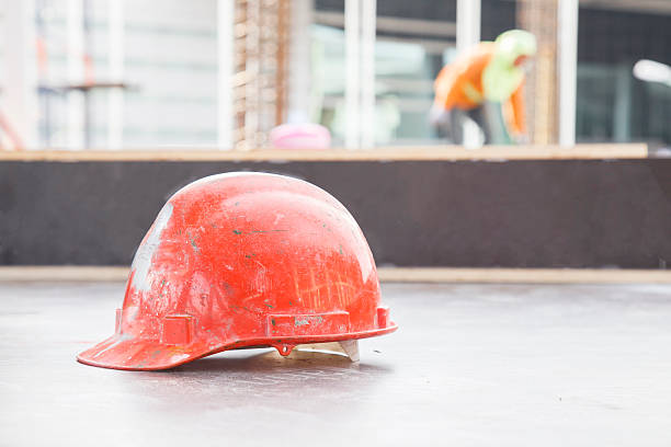 istock Orange safety helmet in construction with worker background. 541991592