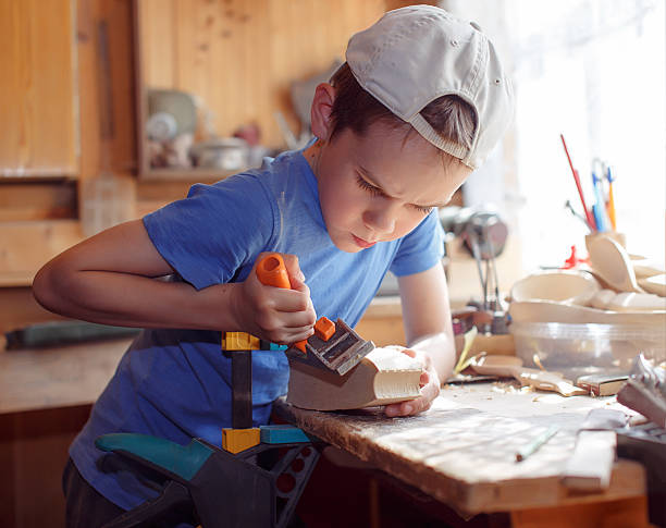 istock child whittling a  carpenter's plane 541992644