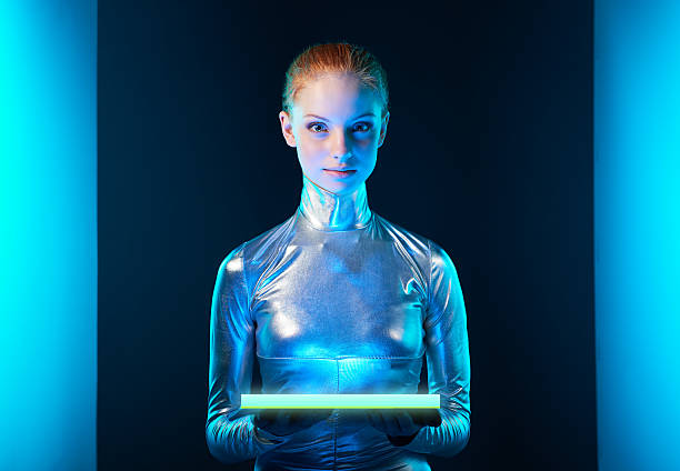Futuristic young woman in silver clothing Futuristic cyber young woman in silver clothing holding lighting panel in her hands with copy space for your product. Sci-fi style. cosmonaut photos stock pictures, royalty-free photos & images