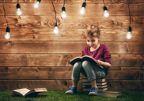 niña leyendo un libro - fairy child outdoors fairy tale fotografías e imágenes de stock