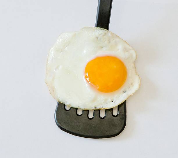 istock Close up of fried egg on plastic spatula 541997068
