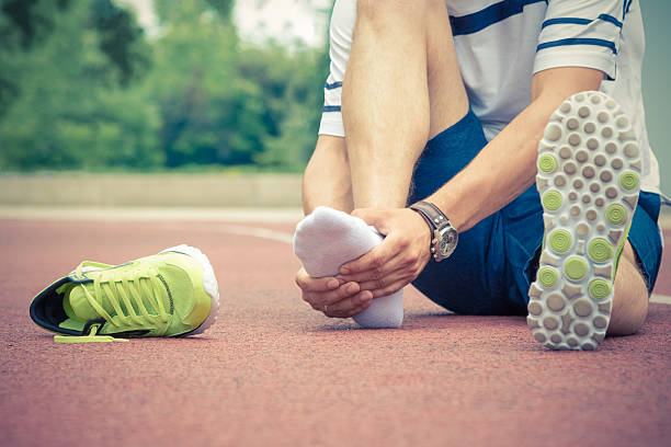 jogger controlla se la caviglia è rotta o contorta - twisted ankle immagine foto e immagini stock