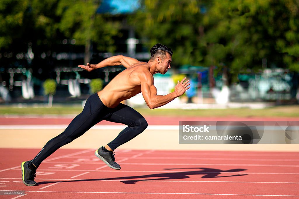 Young muscular man ready to start a track meet. Young muscular man in gym doing exercise. Showing his muscles. Active Lifestyle Stock Photo