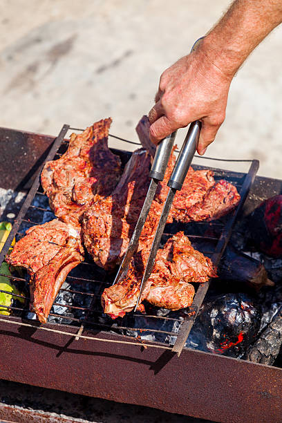 istock Roasted meat on the grill with male hand. 542005230