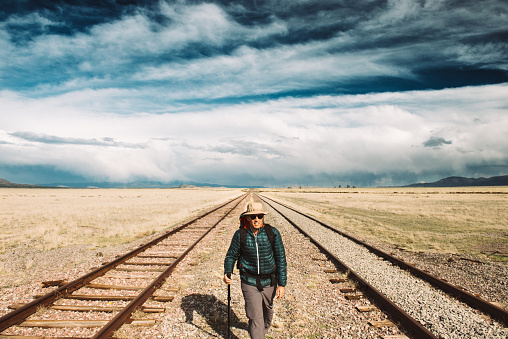 Backpacker hiking in between railway tracks in New Mexico. USA.