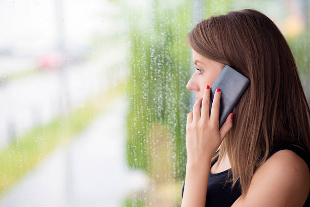 istock Women using smart phone and  sitting near window 542006538