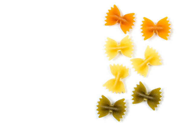 massa farfalle colorida isolada em fundo branco - bow tie pasta italian cuisine bow heap - fotografias e filmes do acervo