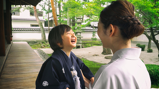 A young boy dressed in ceremonial kimono for the Shichigosan ceremony sitting with his mother. Taken on location in Kyoto, Japan.