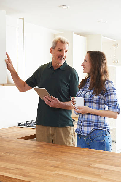 istock Woman With Carpenter Looking At Plans For Kitchen 542011282