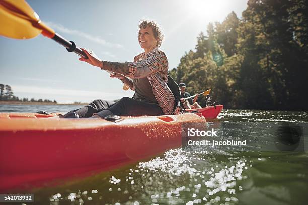 Senior Woman Canoeing In Lake On A Summer Day Stock Photo - Download Image Now - Mature Women, Senior Adult, Kayak