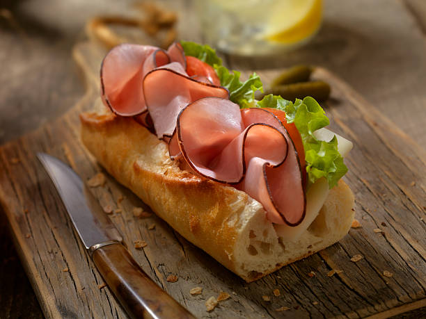schinken und käse-sandwich auf ein baguette - cheese focus on foreground on top of portion stock-fotos und bilder